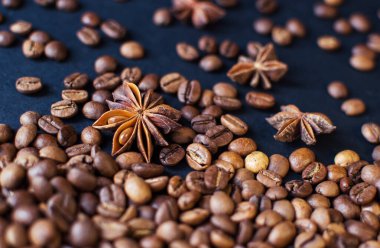 Koyu aromalı kahve çekirdekleri ve yıldız anis. Kahve arka planı. Mesajlaşmak için düz yerde yatıyordu. Yukarıdan görünüm.