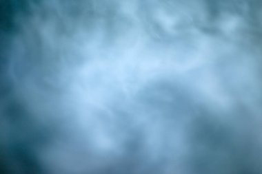 Dalgalanan dumanın dokusu mavi gece gökyüzüne karşı