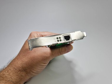 Bir adam elinde bilgisayar ağı adaptör kartını tutuyor, kapat.