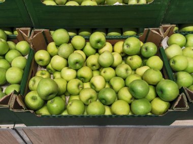 Bir mağazada sergilenen sandıktaki yeşil elmalar