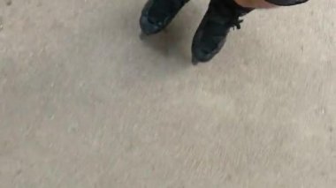 Kayalık asfalt yüzeyde kayan bir adamın bacakları, yukarıdan görünen manzara. Yavaş çekim