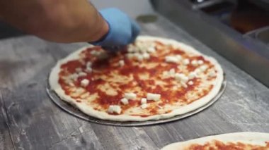 Şef mutfakta pizza hazırlıyor.