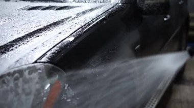 Araba bir oto yıkamada köpükle yıkanır.