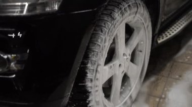 Araba bir oto yıkamada köpükle yıkanır.