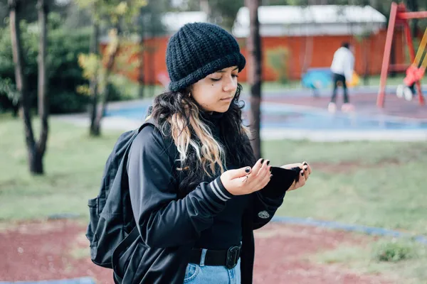 Parktaki Latin üniversiteli kız yüz maskesi takıyor.