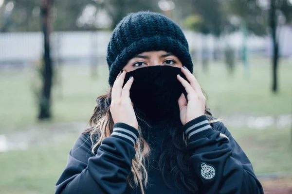 Adolescente latina universitaria en el parque con una máscara facial — Foto de Stock