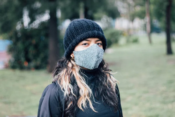 Latina adolescente universidad chica de pie en el parque con mascarilla en — Foto de Stock