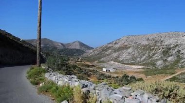 Kırsal bir arazide arabadan alınan POV ve yolda küçük beyaz bir ev..
