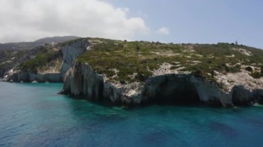 Akdeniz manzarası, turkuaz su ve dağın yakınındaki teknelerin insansız hava aracı görüntüleri..