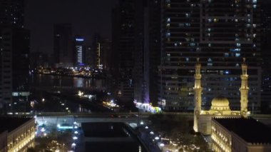 Gökdelenler arasında bir gece şehrinin insansız hava aracı görüntüsü. Gece köprüsünün üzerinden uçmak.