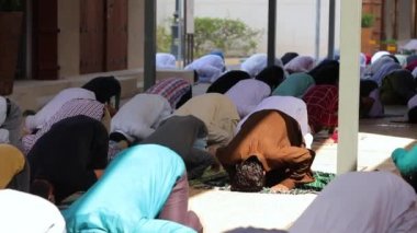 Muslim people in praying in the mosque. bowing down in prayer, kneeling.