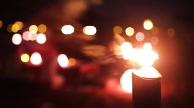 Abstract blurred close up of the torch on the beach, with blurred lights of candles on the background.