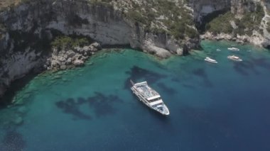 Turkuazda güzel beyaz bir yatın insansız hava aracı görüntüsü. Yüksek kaliteli FullHD görüntüler