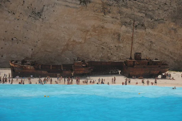 Blue turquoise ocean lagoon with huge rusty ship wreck on the public beach... High quality image.