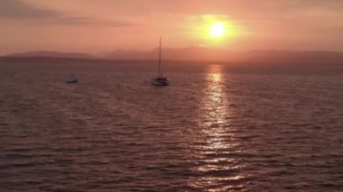 Lonely luxurious sailboat, yacht in red ocean bloody velvet sunset golden hour. High quality FullHD footage