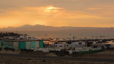 Slow time lapse amazing golden hour crimson sunset, boats, fishermen village. Peru. High quality FullHD footage