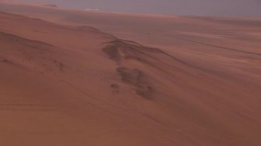 Aerial shot of crimson Peruvian dunes, Paracas National reserve..