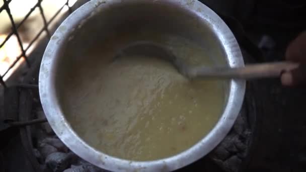 Black Hand Stirs Liquid Whitish Porridge Iron Bowl Iron Scoop — Vídeo de Stock