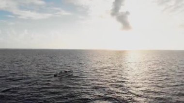 Drone follows luxury yacht boat in the deep blue ocean sunny and cloudy sky...