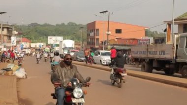 Afrika işlek caddesi, Uganda yolunda trafik. Scooterlar, yayalar, arabalar...