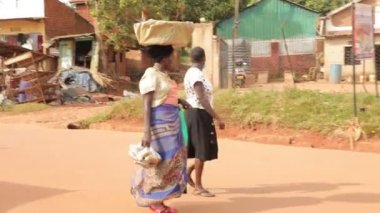 African women are carrying banana piles on their heads, African slum culture...