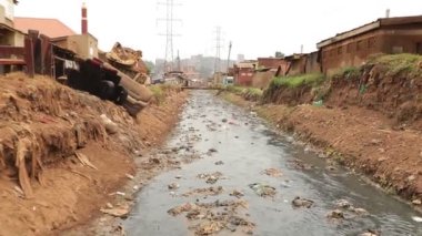 Afrika gecekondu sokağı, Uganda Kampala 'nın çok fakir bir bölgesi, sığ bir nehir....