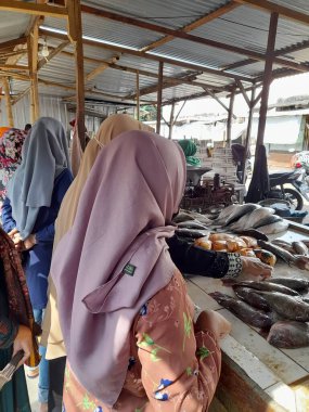 Balık satıcısının dükkanında alım satım yapan ve seçen alıcılar.