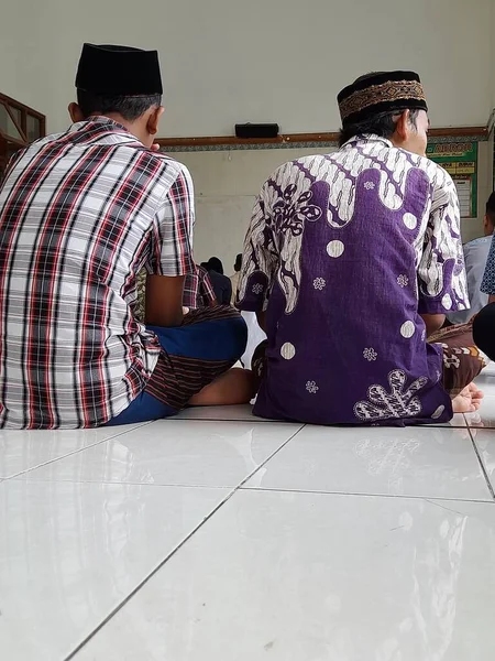 Batik Giyimli Kafatası Şapkalı Iki Genç Sivrisinek Töreninde Vaaz Dinliyorlar — Stok fotoğraf