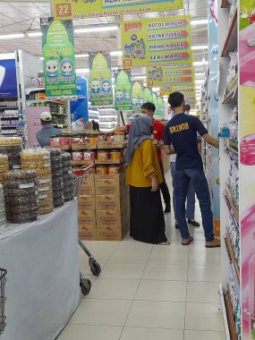 Modern tezgahtarlar alışveriş yapanlara servis yapmakla meşgul görünüyorlar.