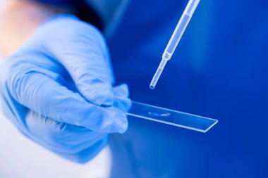Biyolojik örnekleri bir bardağa yüklemek için kullan-at pipet kullanan araştırmacıyı kapatın. DNA testi, aile bağları kavramı