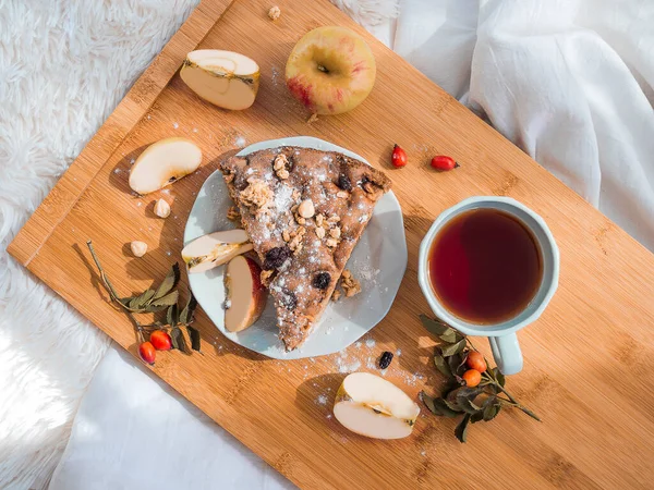 Vista superior del desayuno en la cama con pastel sabroso y t en bandeja de madera. Mañana romántica de vacaciones — Foto de Stock