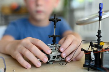 Gelişmiş zeki çocuklar için hobiler. Genç mucit oğlan, dikkatle drone kuruyor.