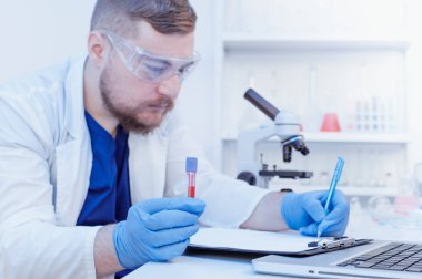 Virolog doktor laboratuvarda numune alarak kan testi yapıyor. Covid-19 kan testi konsepti
