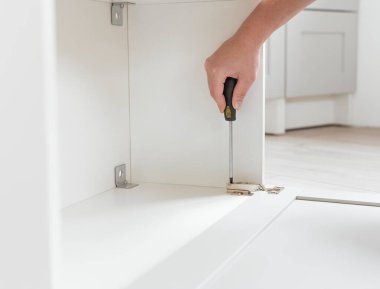 Tornavidayla mobilya montajı, erkek elini kapat. Bireysel bir projeye göre mutfak mobilyası üretimi