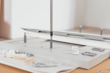 Marangoz hizmetleri konsepti. Mutfak mobilyalarını tornavidayla yere asmak.