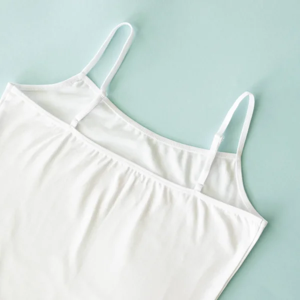 Camiseta de mujer blanca soltera sin mangas aislada en azul. Concepto de algodón natural y ropa interior casual — Foto de Stock