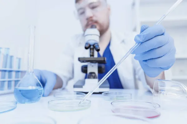 Mikrobiologen tittar på en koloni av virus i laboratoriet. Begreppet blodprov — Stockfoto