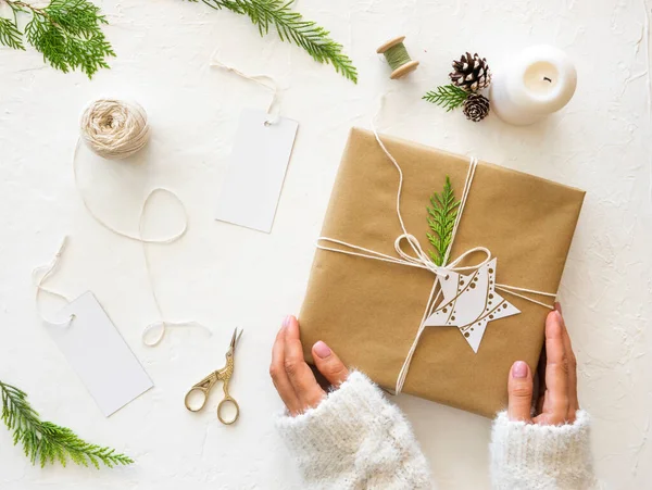 Mãos femininas embrulhando presentes de Natal com papel artesanal. Top vista mockup, flat lay — Fotografia de Stock