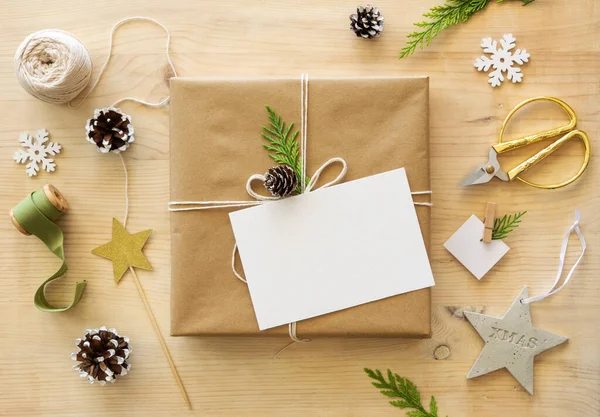 トップビュークラフト紙クリスマスギフトボックス、梱包のプロセス。空のカード、お祝いのクリスマスの装飾とフラットレイアウトのモックアップ — ストック写真