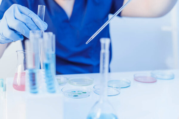 Laboratory testing of blood samples. Scientist hold the pipette and drop the chemical liquid for research and analysis in a laboratory.