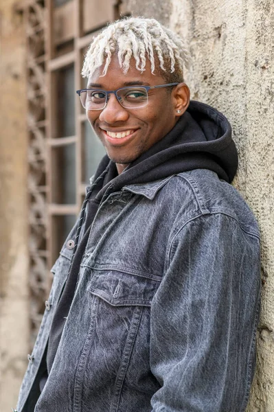 Conceito de moda juvenil. Close up retrato de belo menino adolescente afro-americano com dreadlocks relaxado contra a parede — Fotografia de Stock