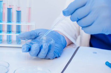 Salgın sırasında sağlık sigortası. Üniformalı ve eldivenli tıp doktoru aşı antiretroviral Coronavirus covid 19 'u virüslü test tüplerine yerleştirdi.