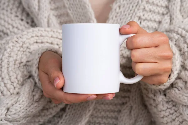Woman in knitted sweater holding white mug in hands. Winter cup Mockup for Christmas individual gifts design — Stock Photo, Image