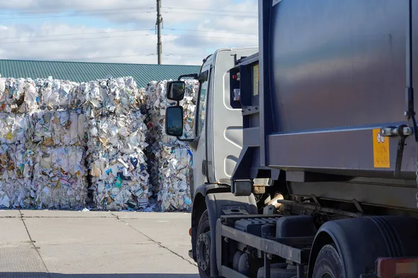 Çöplüğün arka planındaki bir kamyonun fotoğrafı..