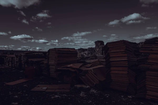 Photo of a large amount of cardboard in a garbage dump.