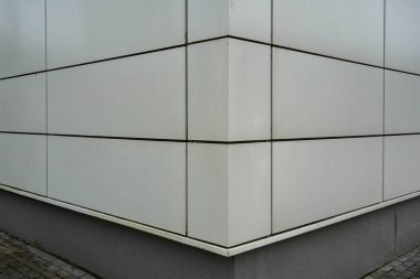 Beyaz duvarın köşesindeki karoların yakın plan fotoğrafı..