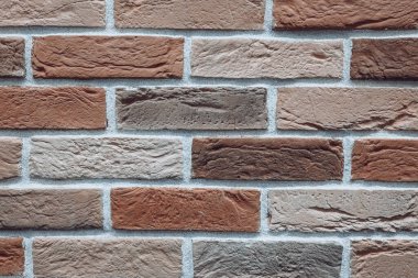 Kahverengi tuğlalı bir duvarın fotoğrafı.