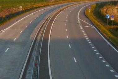 Beyaz yol işaretli gri bir yolun fotoğrafı..