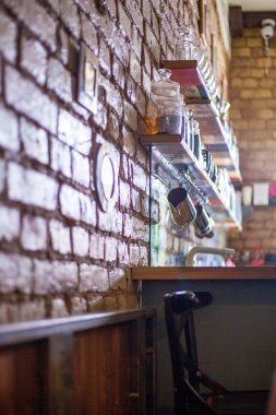 Kafede rafları olan tuğla bir duvarın fotoğrafı..