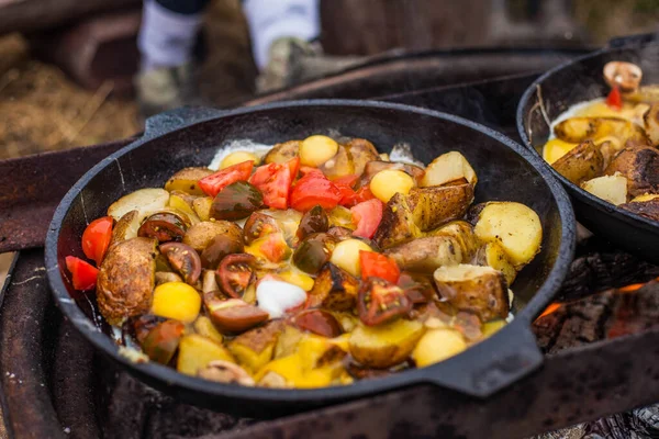 Doğada bir kazanda patates ve domates pişirme fotoğrafı..